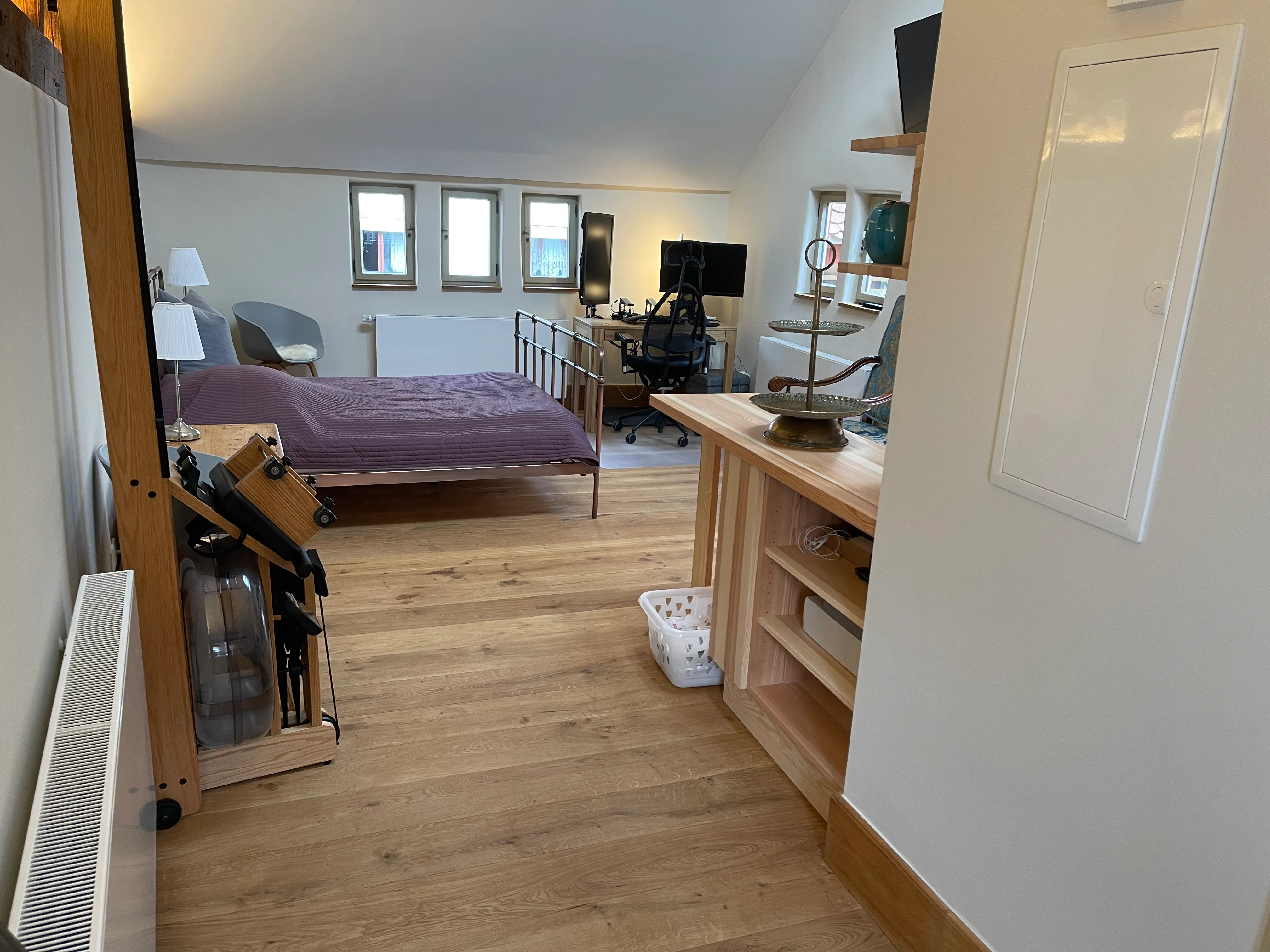 Heller Wohn-Schlafbereich mit Doppelbett und Arbeitsplatz