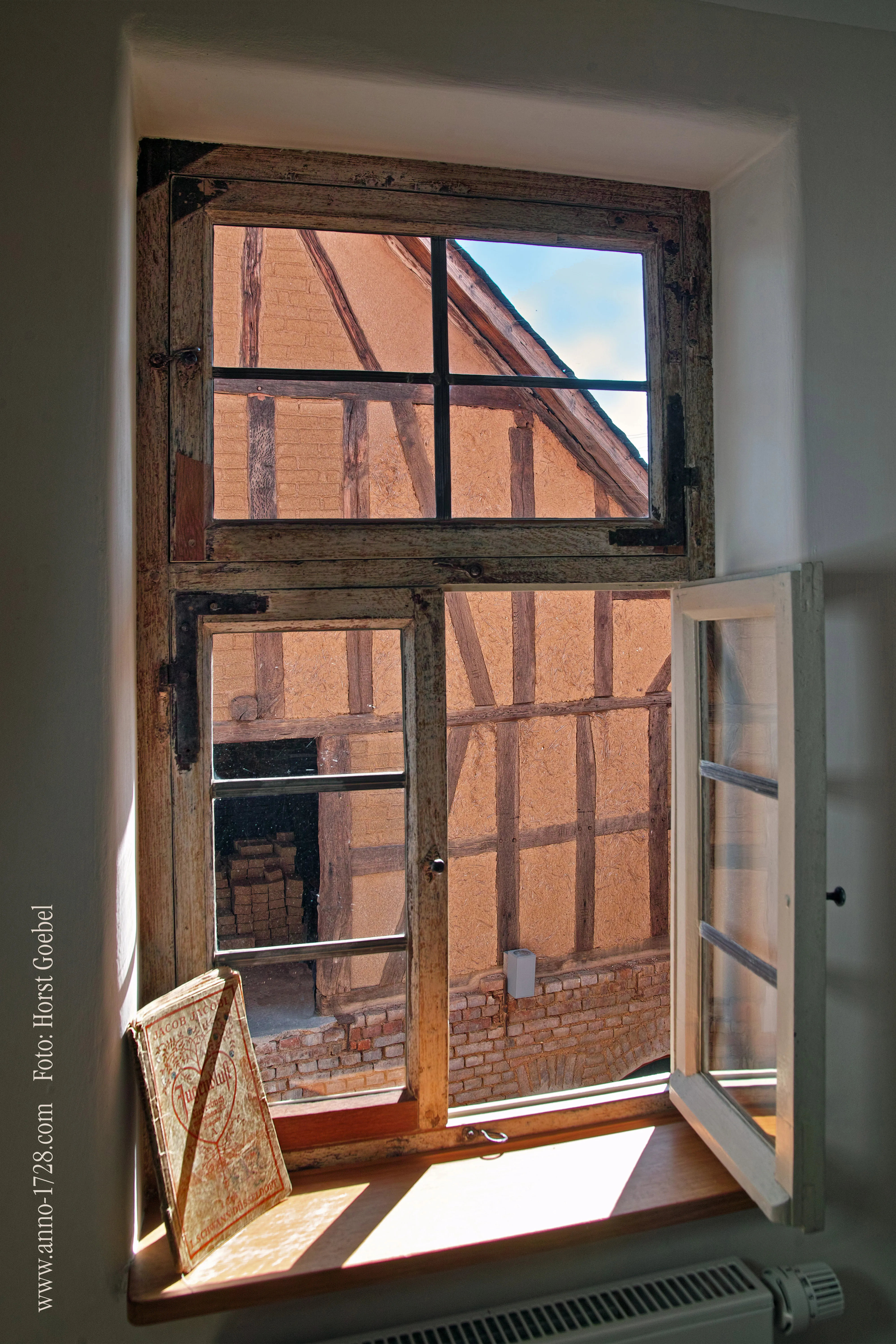 Geöffnetes Fenster mit Blick auf die Fachwerkfassade